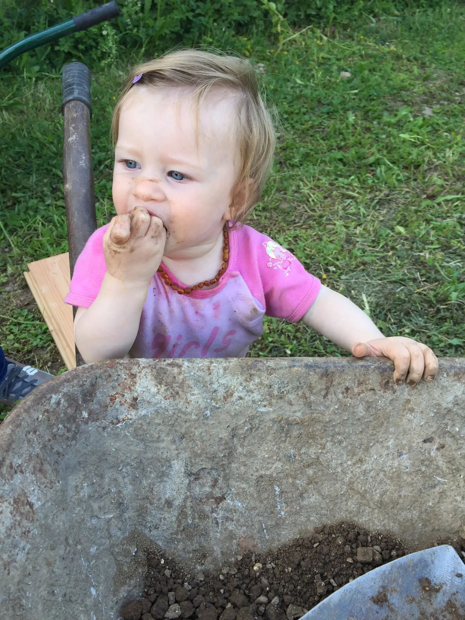 Olivia with dirt on her face, a muddy hand near her mouth